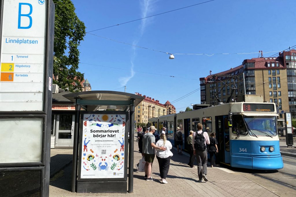 Flera personer på väg att stiga på en spårvagn vid Linnéplatsens hållplats.