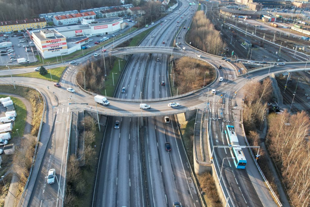 Drönarbild över rondellen i Munkebäcksmotet. Trafik på E20 syns mitt i bilden.